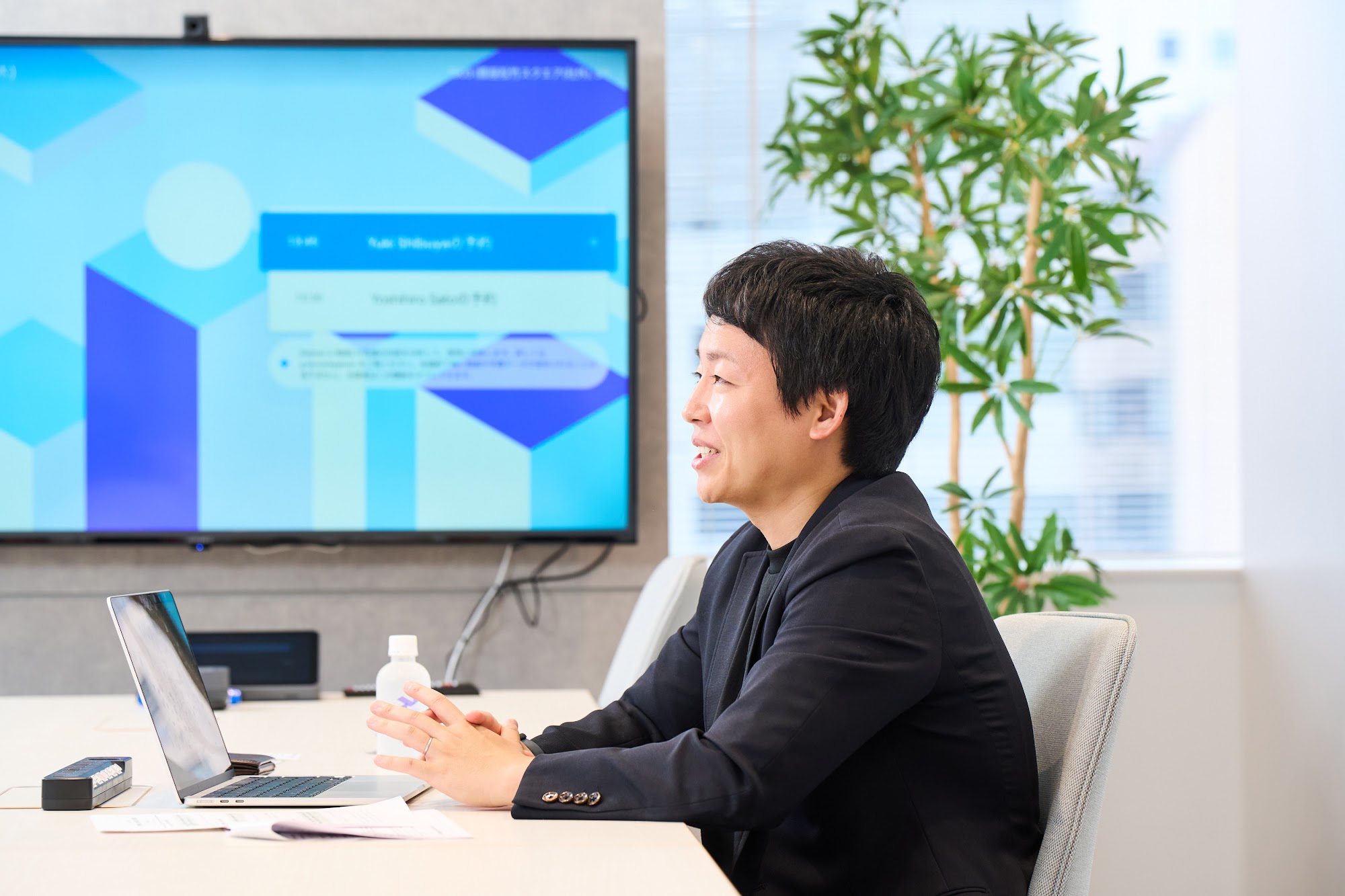 LayerXのロゴが映るモニターを前に話す清水敬大氏